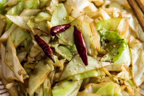 Infuse the oil with aromatics and then toss at a high heat, this adds a smoky flavor to the sweet fried cabbage and makes a quick and delicious side dish.
