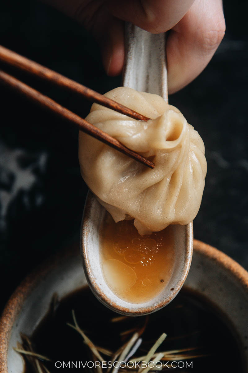 Eating soup dumplings with soup in the spoon