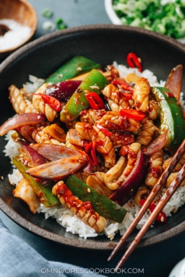 Stir fried spicy squid over steamed rice close up